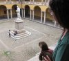Lesley and Otter look at the statue of Alexandro Volta, in the courtyard of the University